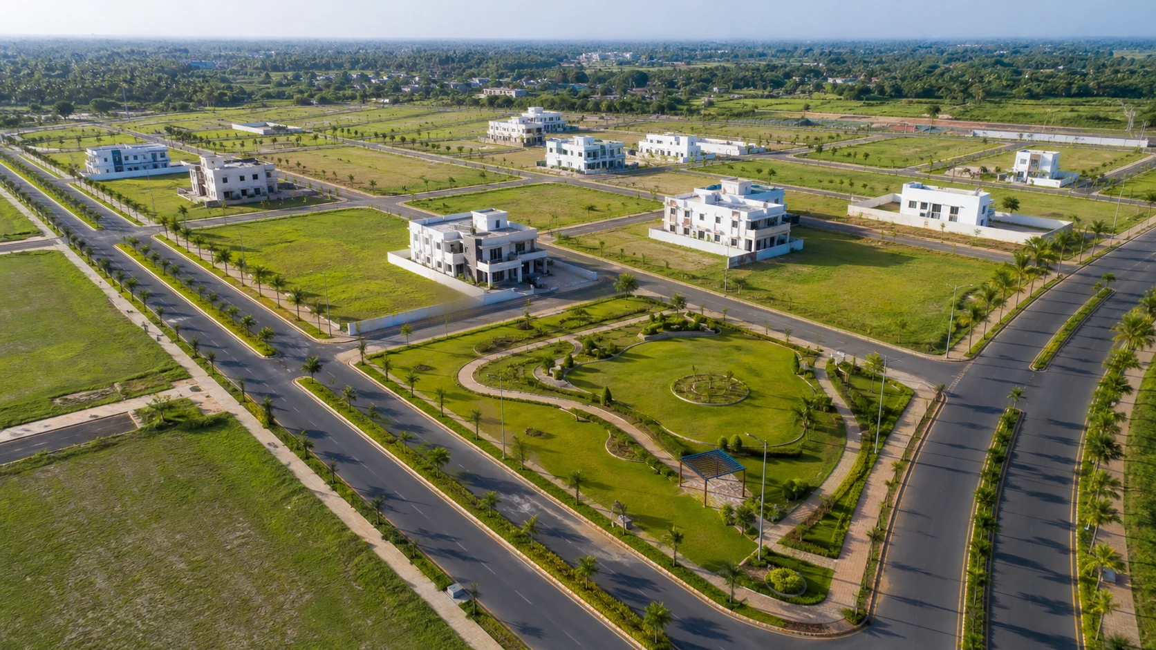 A bright daylight aerial view of a planned villa plot community with landscaped parks and roads